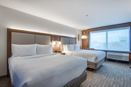 a hotel room with two beds and a large window at Holiday Inn Express & Suites Dallas North - Addison by IHG in Addison