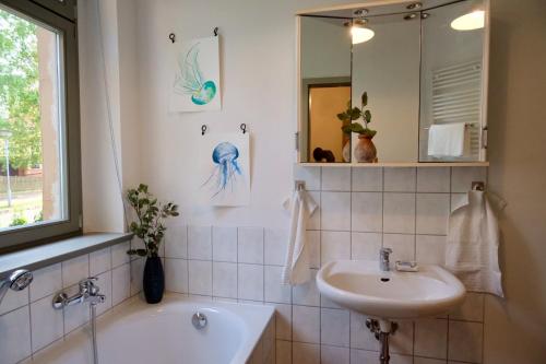 a bathroom with a sink and a tub and a mirror at 110 qm Ferienwohnung Stadtvilla Halberstadt - Dem Tor zum Harz in Halberstadt