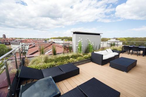 a balcony with chairs and tables on a roof at Apartamenty Rondo in Świnoujście