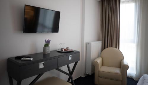 a hotel room with a desk and a tv on the wall at Urban 7 Residence in Bucharest