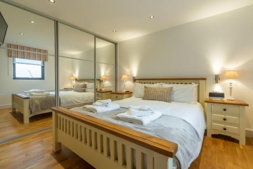 a large bedroom with two beds with mirrors at Stargazy in St. Agnes