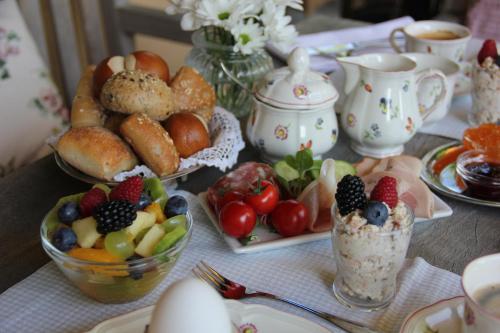 a table topped with plates of food and bowls of fruit at Villa Zollhaus Bed & Breakfast in Türkheim