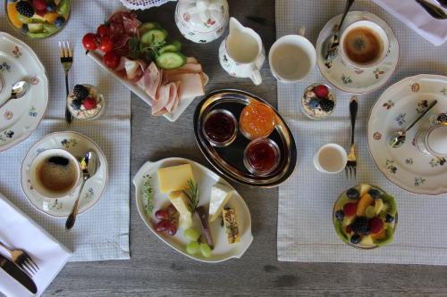 a table with plates of food and cups of coffee at Villa Zollhaus Bed & Breakfast in Türkheim