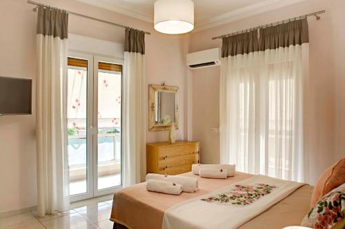 a bedroom with a bed and a large window at NOURI APARTMENT in Corfu