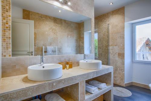 a bathroom with two sinks and a large mirror at La maison d'Hana in Saint-Bonnet-de-Valclérieux
