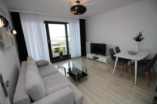 a living room with a couch and a table at Apartamenty Kropla Bałtyku in Darłowo