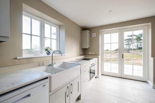 a kitchen with white cabinets and a sink at The Dower House in Sizewell