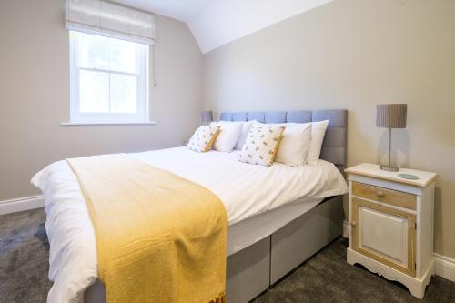 Un dormitorio con una cama con una manta amarilla. en The Dower Retreat en Sizewell