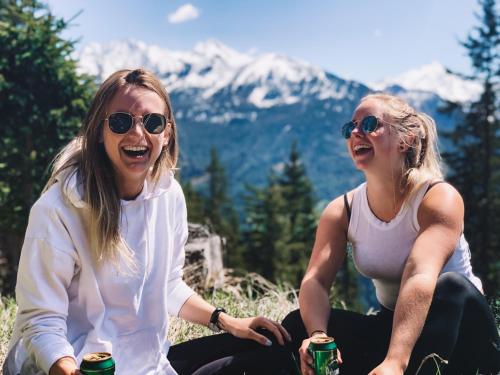 two women sitting on a hill with drinks at SchönBerg hotel b&b in Rio Bianco