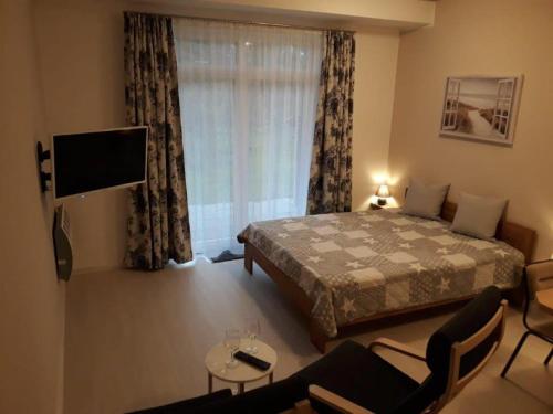 - une chambre avec un lit, une télévision et un canapé dans l'établissement Haus Pellworm, à Sankt Peter-Ording