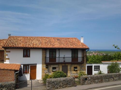 a white house with a red tile roof at Albergue El Pino in Cóbreces