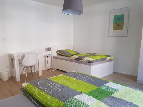 a bedroom with a bed and a desk and a chair at Ferienwohnung in Brackenheim