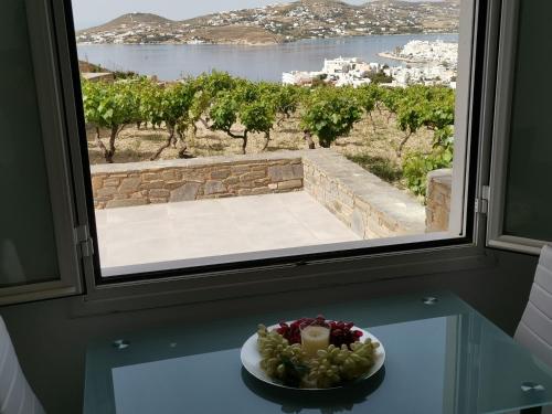 a plate of grapes on a table in front of a window at WONDERFUL SEA VIEW in Parikia