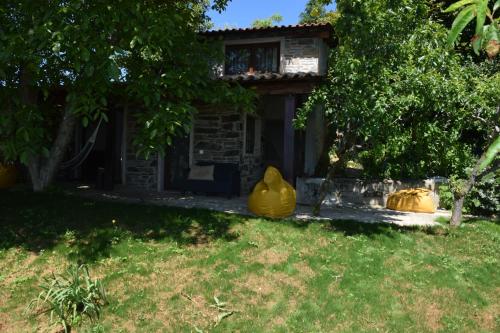 a house with two large yellow vases in the yard at Quinta da Boa Ventura in Bragança