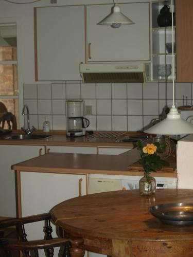 Hurup的住宿－Skibstedgaard，厨房配有一张桌子,上面放着花瓶