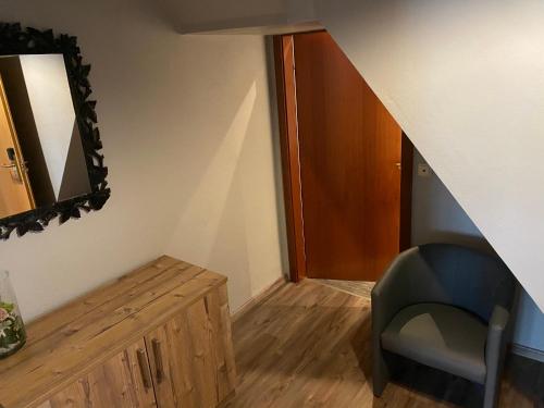a room with a staircase with a mirror and a chair at Hotel Blüchertal in Bacharach