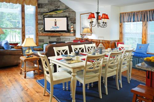 a dining room and living room with a table and chairs at Stormy Point Village in Branson