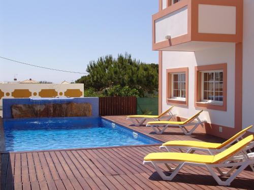
a pool with chairs and a pool table in it at Apartamentos Monte da Vinha I in Albufeira
