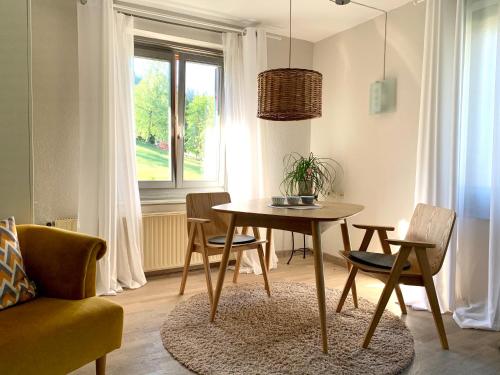 a dining room with a table and chairs and a window at Sonnenhof - Ferienwohnung in Oberstaufen