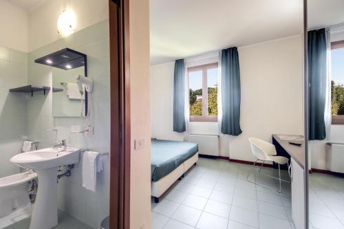 Hotel Alba Roma في روما: حمام الفندق مع سرير ومغسلة