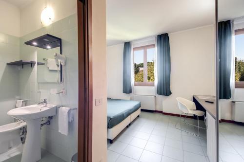 La salle de bains de l'hôtel est pourvue d'un lit et d'un lavabo. dans l'établissement Hotel Alba Roma, à Rome