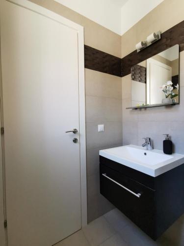 a bathroom with a sink and a mirror at Sea breeze holiday apartment in Amfilochía