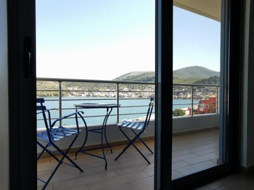 a balcony with a table and chairs and a view of the water at Sea breeze holiday apartment in Amfilochía
