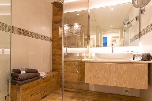 un baño con lavabo y ducha en Maurers Schlierseetraum 1 hochwertige Erdgeschosswohnung mit allen Raffinessen erfreut sich auch Urlauber idealerweise für Paar mit Kindern geeignet und Vierbeiner Dank des tollen Zauns auf der Terrasse stylisch und edel von der Ausstattung mit 64 qm, en Schliersee