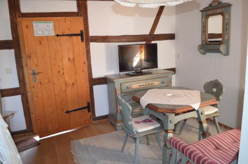 a room with a table and a desk with a television at zum Frongut in Burgstaedt