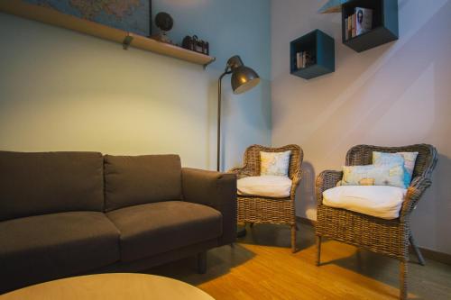 a living room with a couch and two chairs at PTM DownTown Hostel&Suites in Portimão
