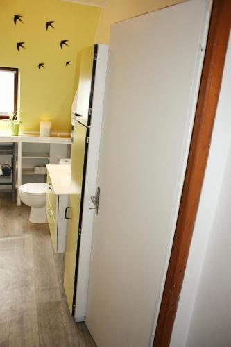 La salle de bains est pourvue de toilettes et d'une porte avec des chauves-souris sur le mur. dans l'établissement Aux 6 hirondelles, à Ammerschwihr