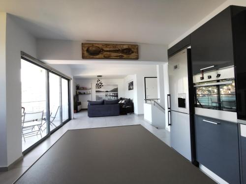 a large living room with a kitchen and a living room at Sea breeze holiday apartment in Amfilochía
