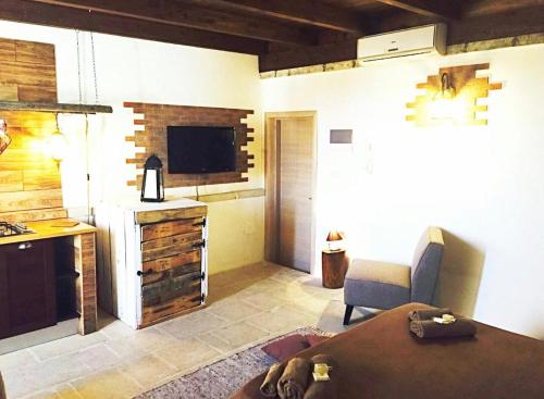 een kamer met een keuken met een tafel en een televisie bij il tramonto in Porto Cesareo