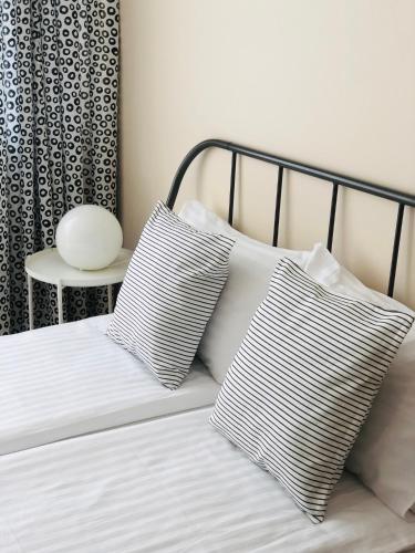 a bed with two pillows on it with a side table at Astos Vila in Palanga