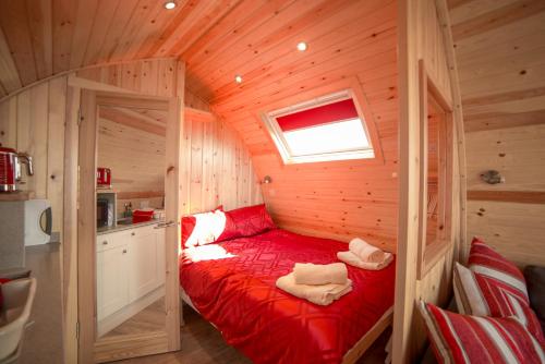 a small room with a red bed in a cabin at Suil na Mara Pod in Lochinver