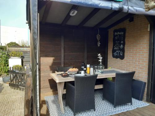 a wooden table and chairs on a patio at Bed & Breakfast De Schans in Makkum