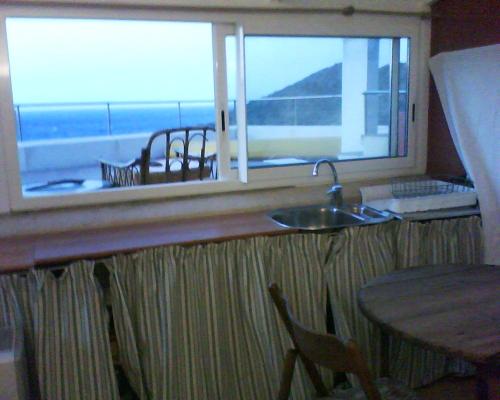 una cucina con un lavandino e una finestra con un tavolo di Barca Serena a Port de la Selva