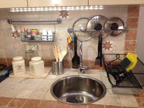 un bancone della cucina con lavello e utensili in acciaio inossidabile di Tufoletto a Pitigliano