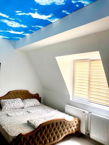 a bedroom with a bed and a sky painted on the ceiling at Apartment Duplex in Pančevo