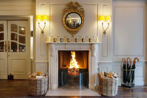 een woonkamer met een open haard en een spiegel bij Durrants Hotel in Londen