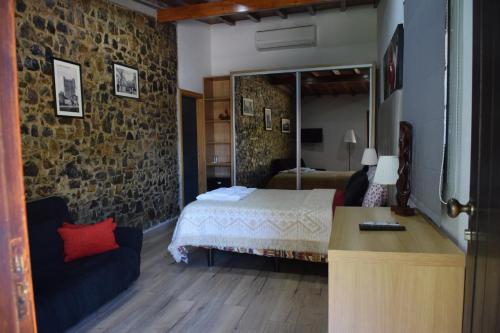 a bedroom with a bed and a stone wall at Quinta da Boa Ventura in Bragança