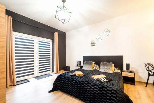 a bedroom with a large bed and a large window at Apartament Perła Pienin in Dębno