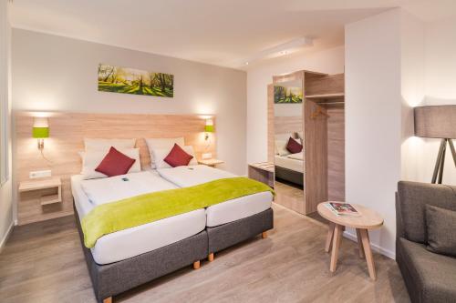 um quarto com uma cama grande e um sofá em Landhotel Zur Bretzel em Babenhausen