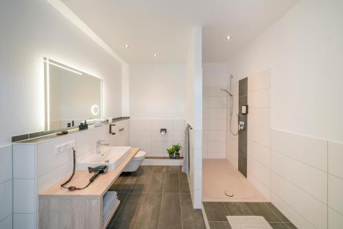 a white bathroom with a sink and a toilet at Landhotel Zur Bretzel in Babenhausen