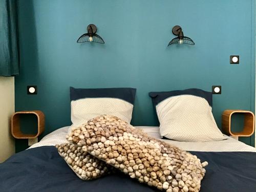 a bed with a blanket on it with two lights at LE COSY LOIRE appart in Les Rosiers-sur-Loire