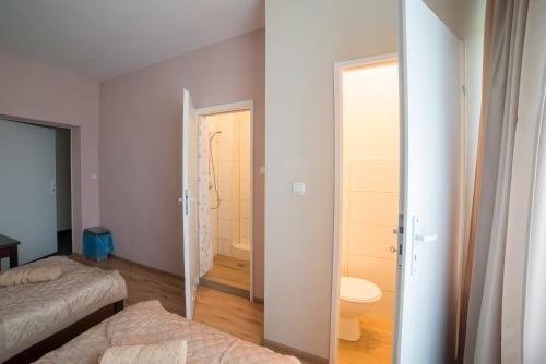 a room with a bedroom with a bed and a bathroom at Strzelec Noclegi in Wrocław