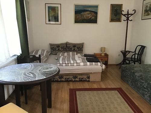 - un salon avec un lit et une table dans l'établissement Mandala apartman, à Dömös
