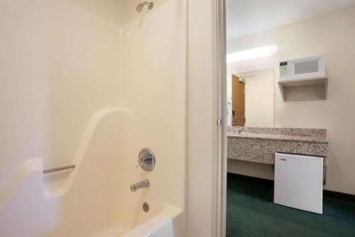 a bathroom with a tub and a sink at Travelodge by Wyndham Morrill in Morrill