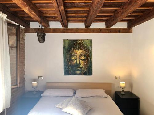 a bedroom with a bed with a painting on the wall at Vivi Vicenza in Vicenza