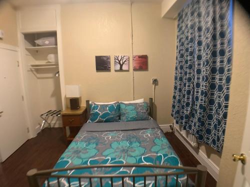 a bedroom with a bed with a blue comforter at Orange Village Hostel in San Francisco